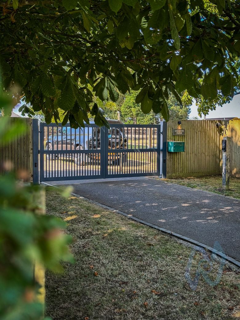 AliGates open-slatted swing gates, closed, seen across the lawn