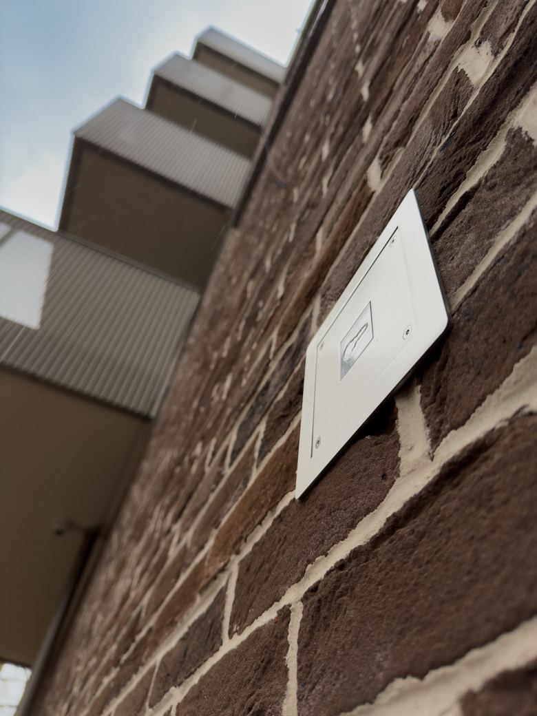 Access reader on the brick wall beside an entrance