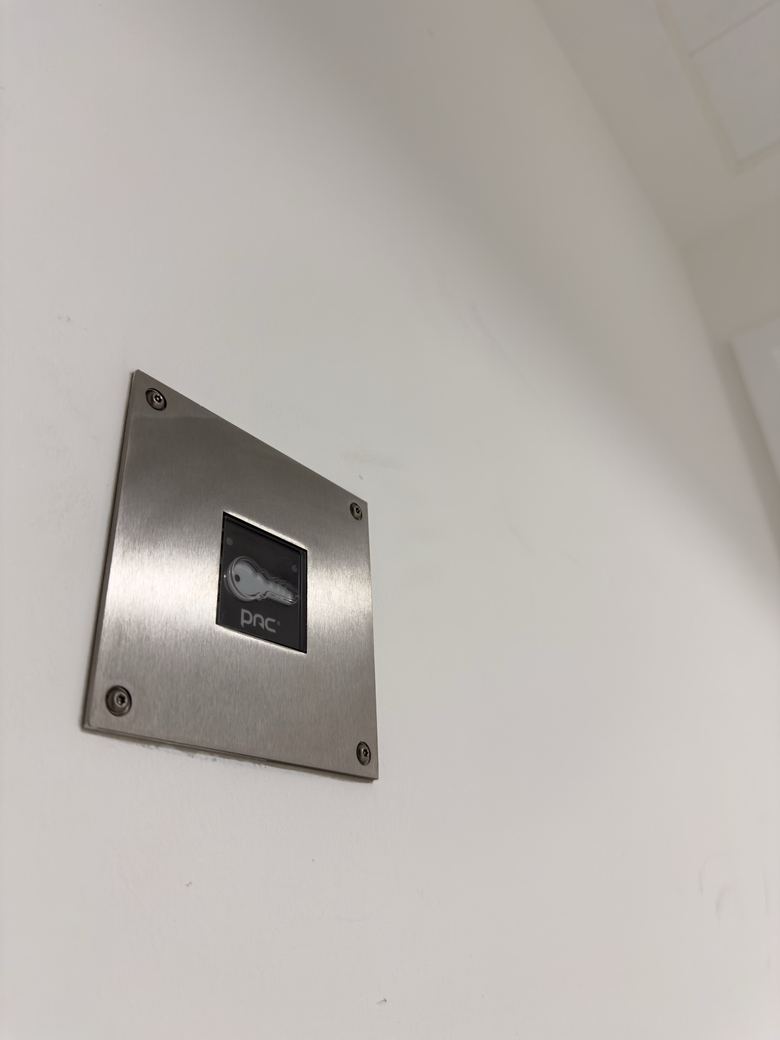 Flush stainless PAC access control reader on a white wall