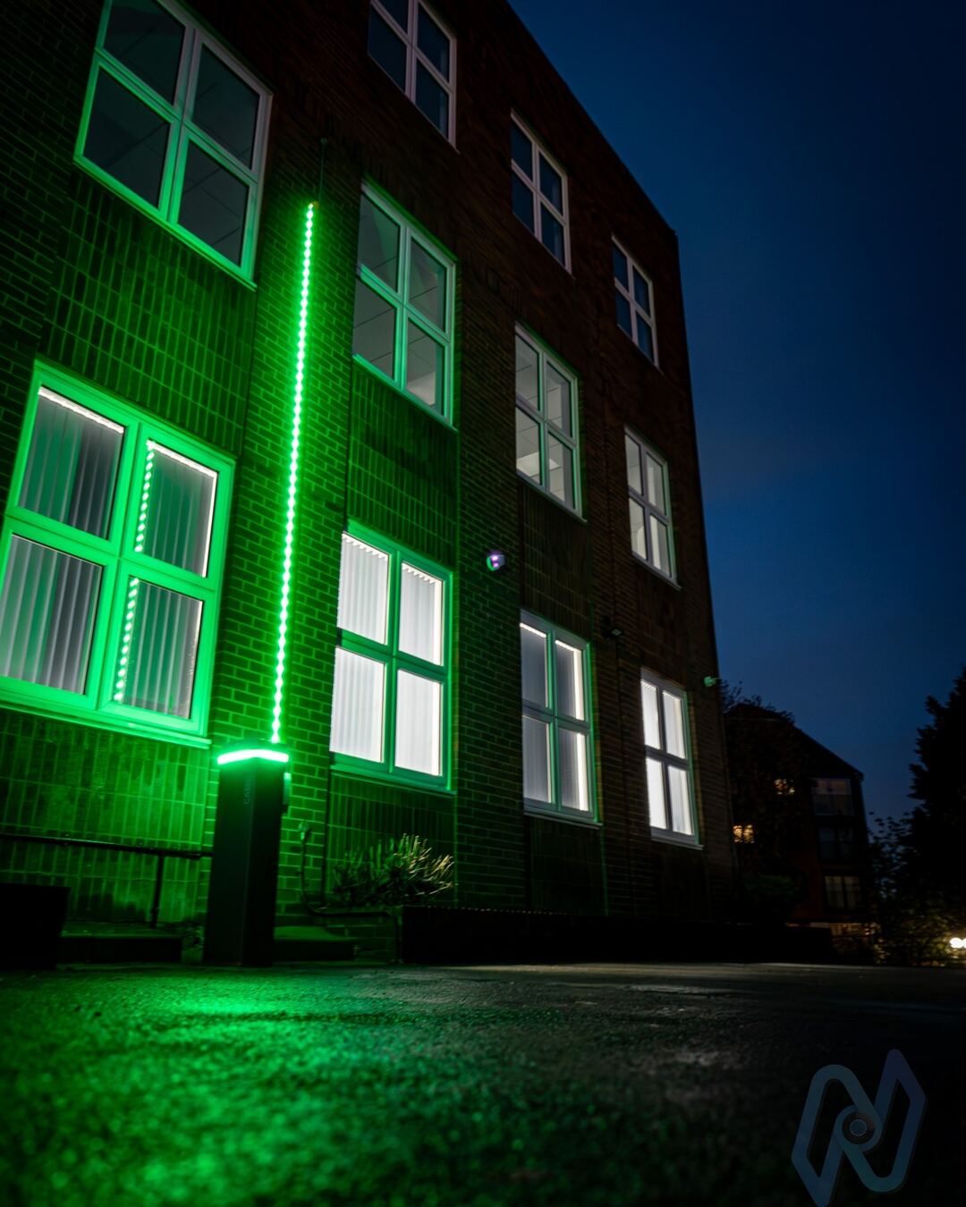 The barrier at night with its boom raised and lit green