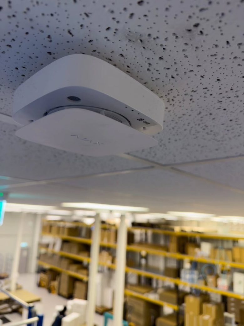 Ajax EN54 wireless detector on the ceiling above warehouse racking