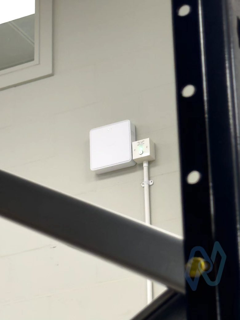 Ajax EN54 Fire ReX wireless range extender mounted on a warehouse wall