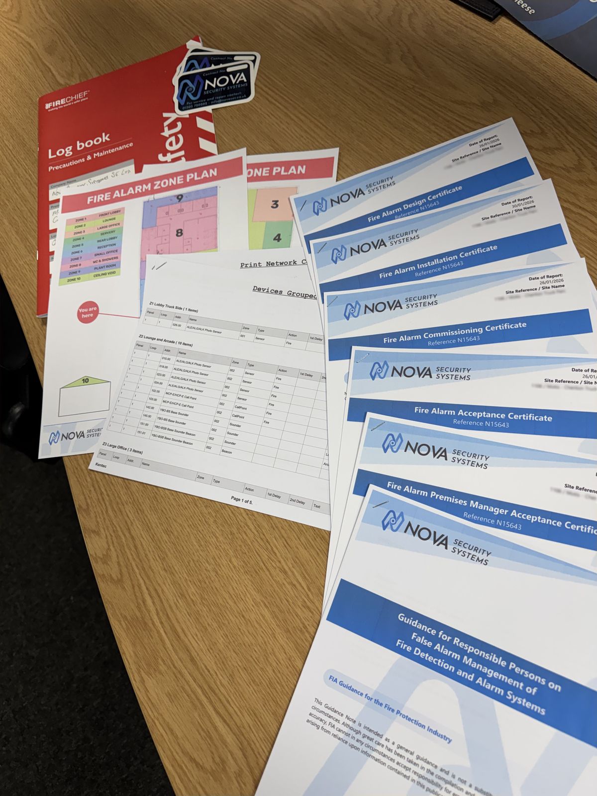 A Nova fire alarm handover pack: logbook, zone plans, device schedule, and design, installation, commissioning and acceptance certificates