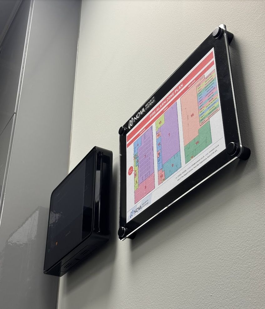 Framed fire alarm zone plan mounted beside the control panel