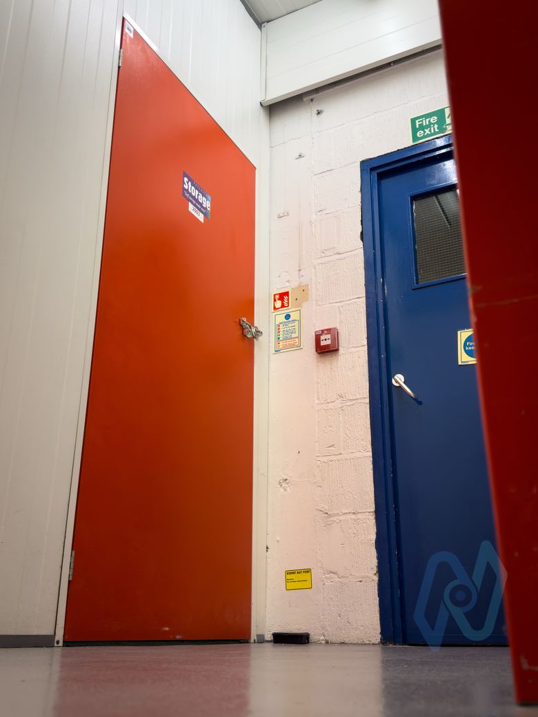 Fire doors and a call point in a storage corridor