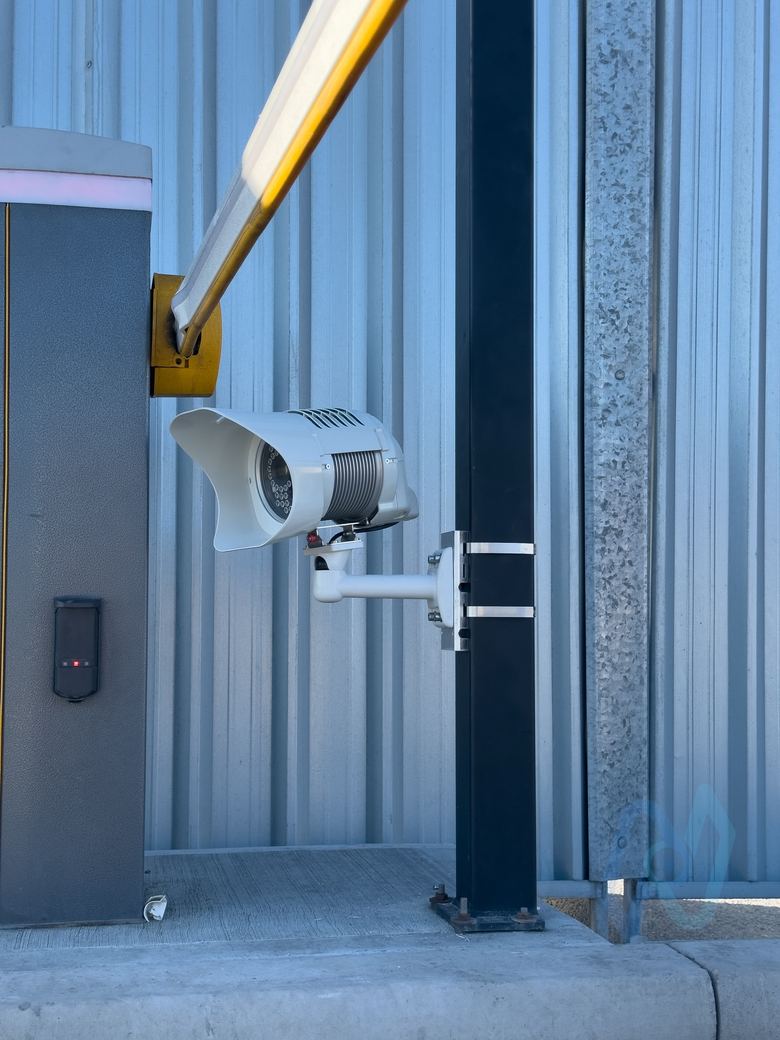 ANPR camera on a post beside an entry barrier and reader