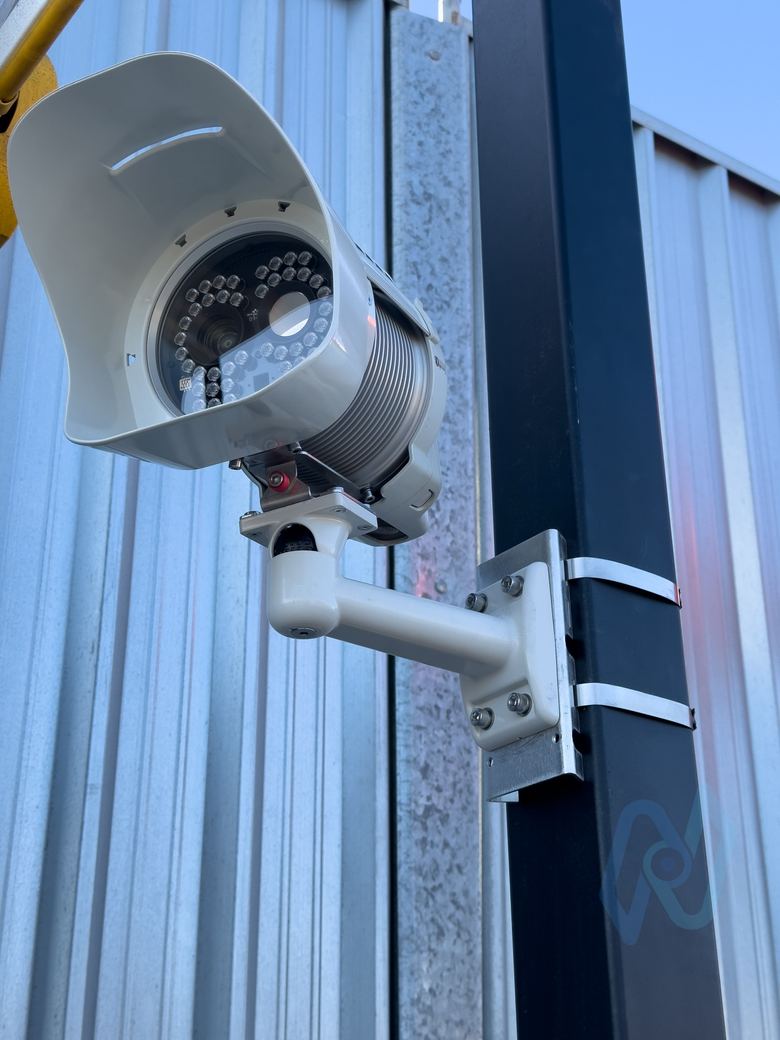 MAV AiQ ANPR camera on a post against a metal-clad building