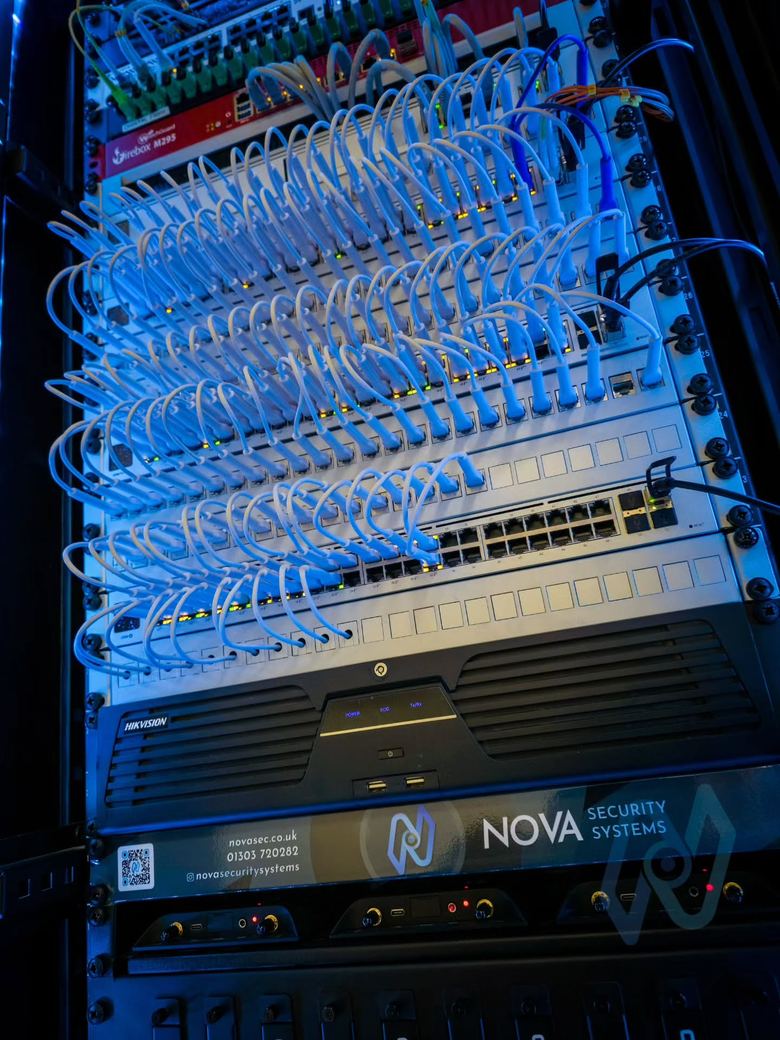 Patched Ubiquiti switches above the Hikvision CCTV recorder and a Nova cabinet label