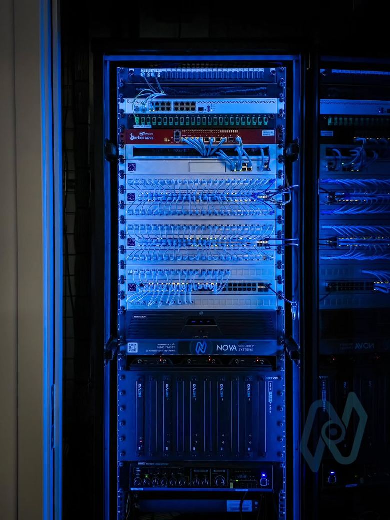 The main network cabinet at Motis, lit blue, with patch panels, switches and recorders