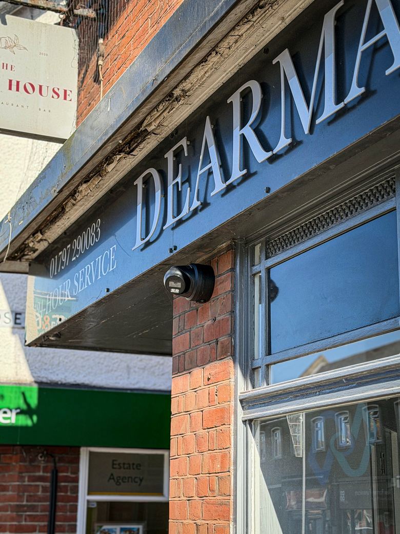 Camera under the Dearman Bartlett sign, covering the shop front
