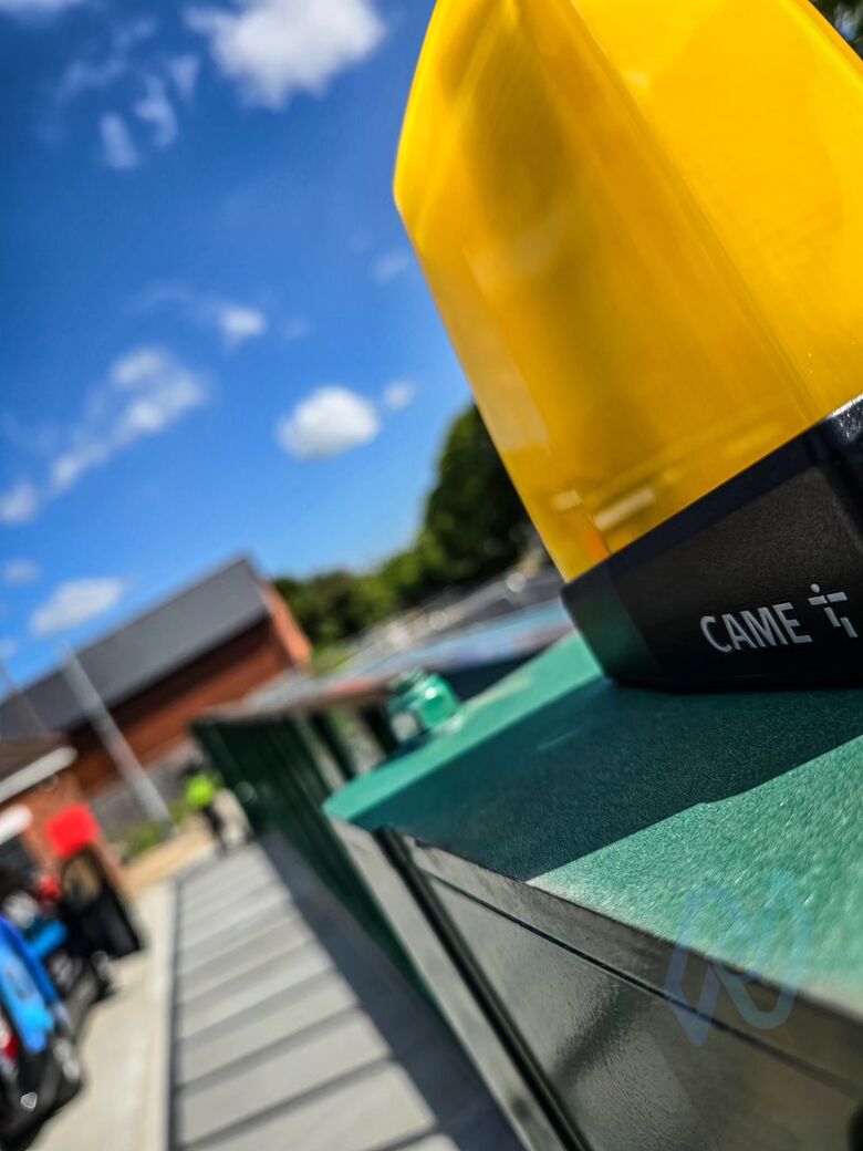 Flashing warning beacon on top of a gate post