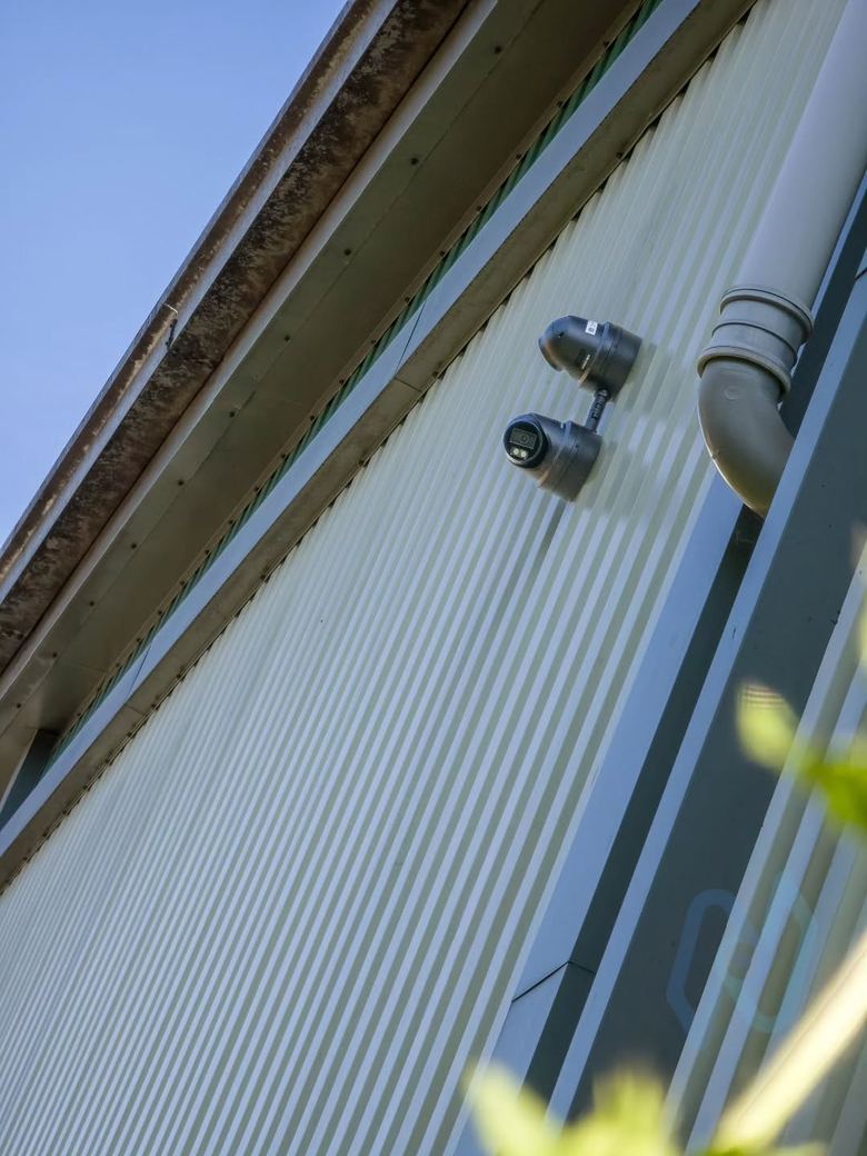 Two turret cameras on the side of a storage building