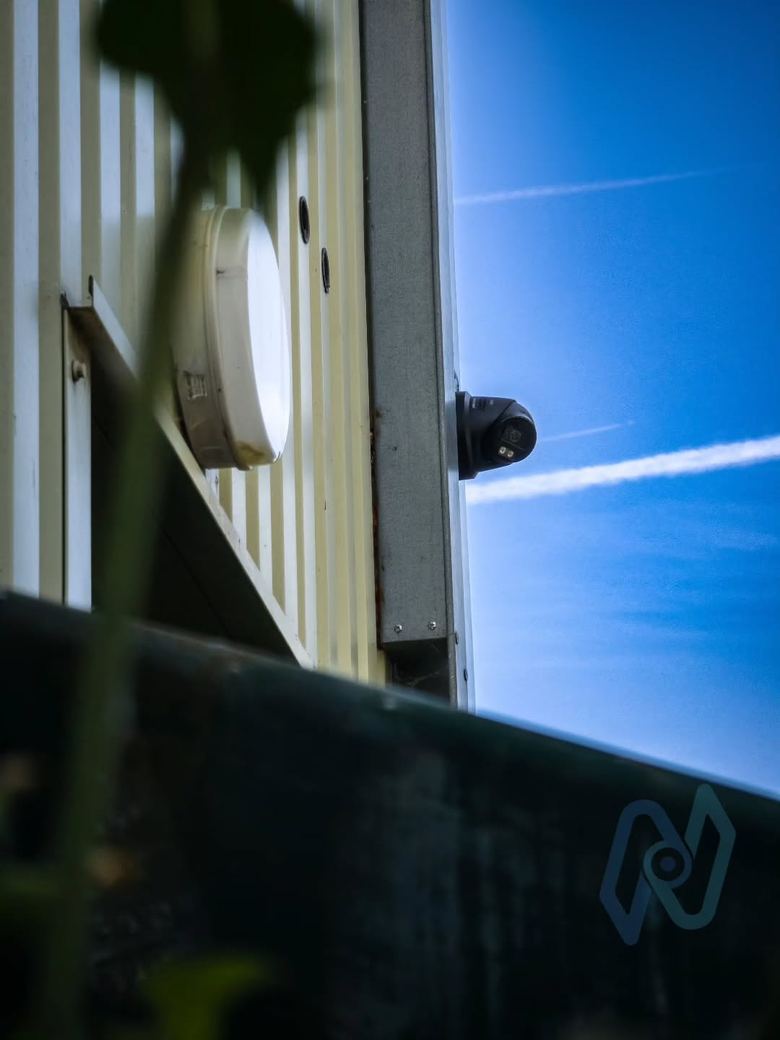 Turret camera on the corner of a storage building against a blue sky