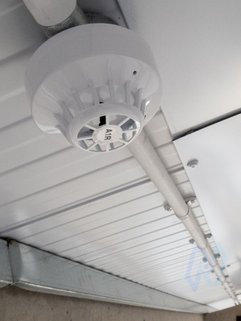 An Apollo Series 65 heat detector on the profiled metal ceiling of the workshop