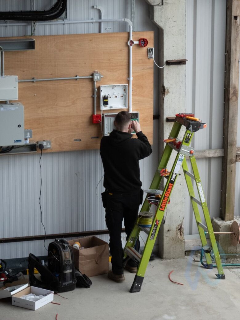 A Nova engineer wiring the conventional fire alarm panel on the workshop’s equipment board