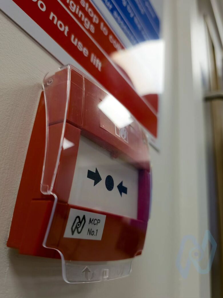 A red manual call point with a clear protective cover and a numbered Nova label