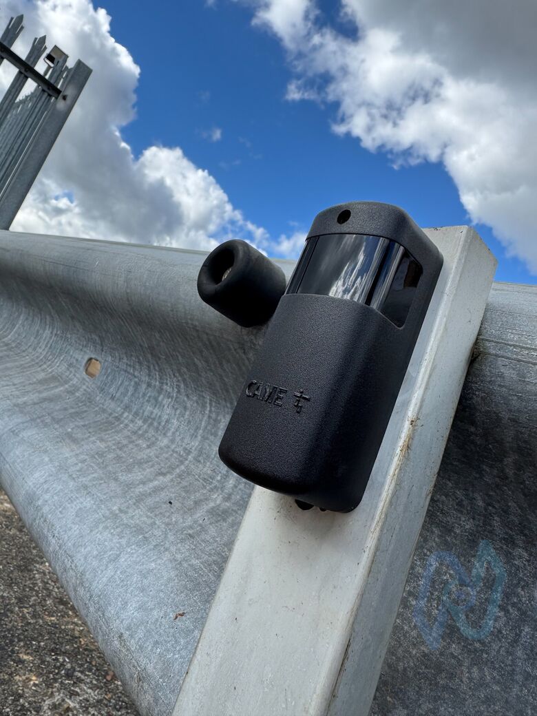 A CAME photocell on a crash barrier beside the gates