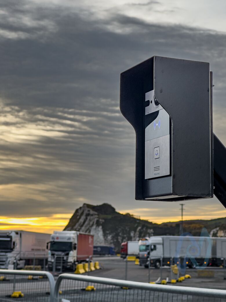 An intercom on a post at Motis Dover, with the white cliffs and lorries behind
