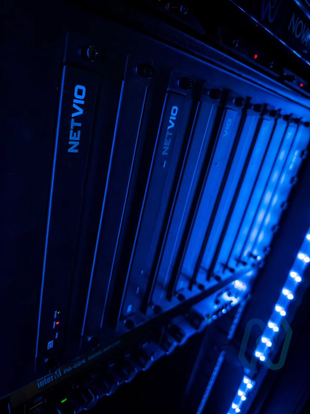 Rack-mounted equipment lit by the cabinet’s blue LED strip