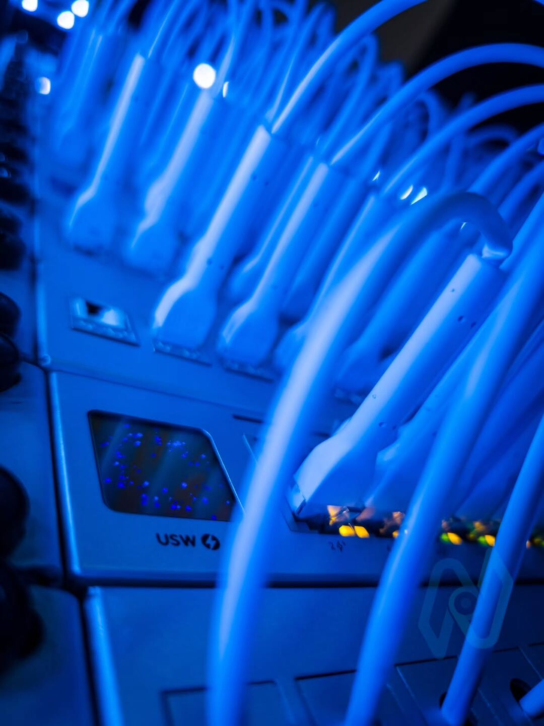 Patch leads plugged into UniFi switch ports, with status lights