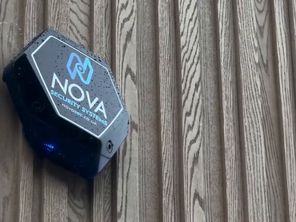 A Nova-branded alarm bell box on timber cladding