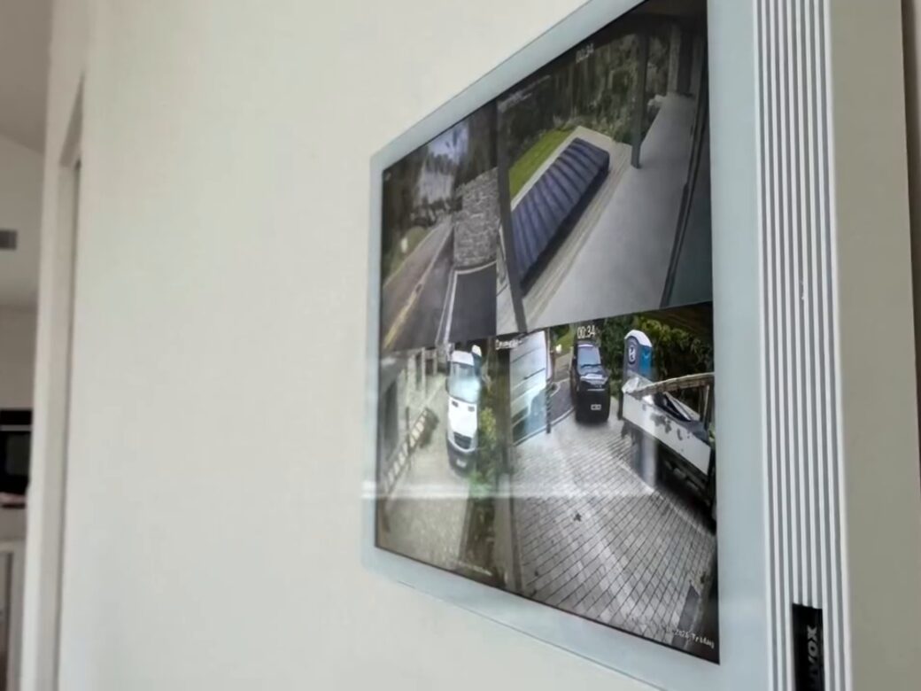 An Akuvox indoor monitor in white on the wall, showing the CCTV cameras