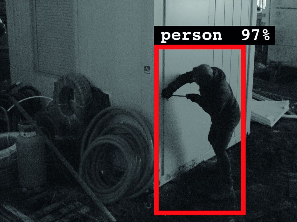 Night-time Reconeyez alarm photo of a person at a door, boxed and labelled person 97% by the AI