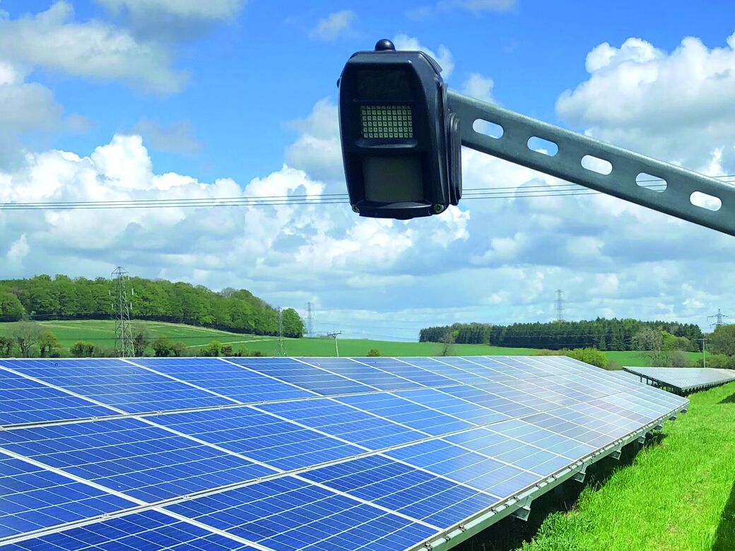 A Reconeyez detector mounted on solar panel racking over a solar farm