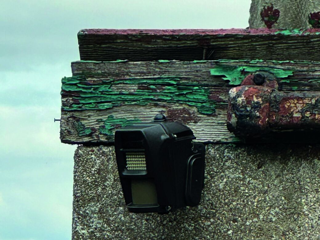 A Reconeyez detector fixed under the eaves of an empty, weathered building